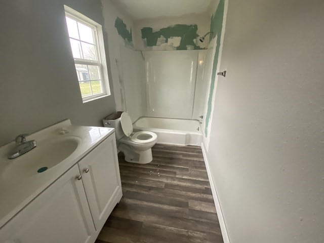 full bathroom featuring toilet, vanity, shower / bathing tub combination, and hardwood / wood-style floors