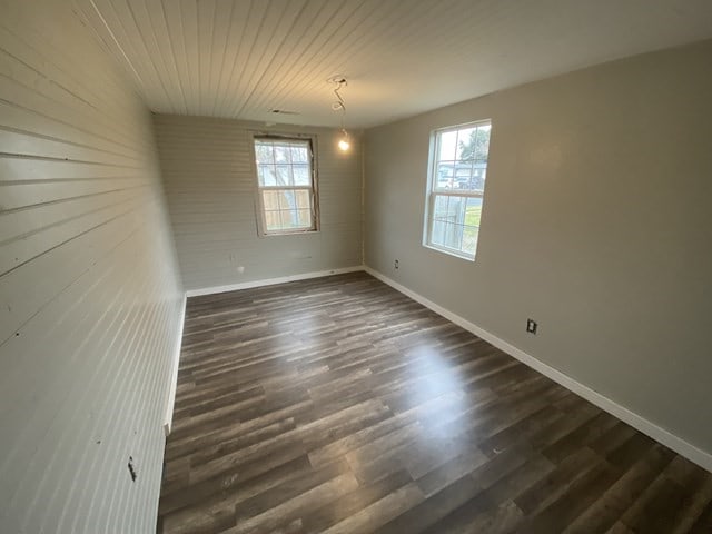 unfurnished room with dark wood-type flooring