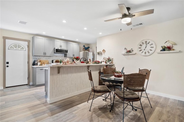 dining space with ceiling fan and light hardwood / wood-style floors