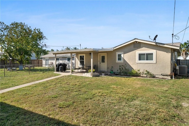 rear view of house with central AC unit, a yard, and a patio