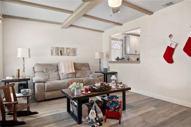 living room featuring beamed ceiling, ceiling fan, and wood-type flooring