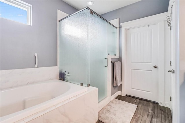 1041 Fiji Dr, Rockport, TX 78382 - bathroom with a bath, a shower stall, wood finished floors, and baseboards