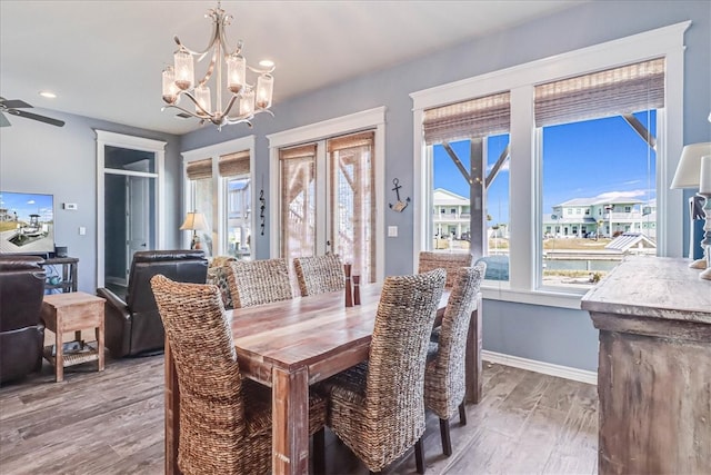 dining room featuring hardwood / wood-style floors and ceiling fan with notable chandelier