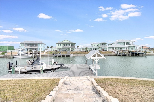 view of dock with a water view and a lawn