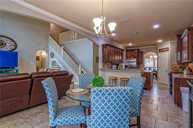 4522 Big Cyprus, Corpus Christi, TX 78410 - dining room with crown molding, visible vents, stairway, a chandelier, and arched walkways