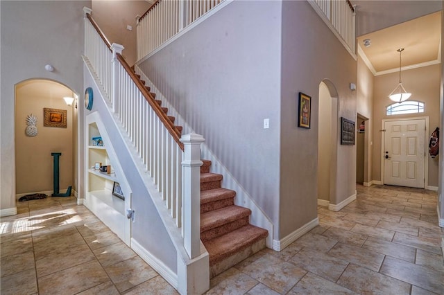 4522 Big Cyprus, Corpus Christi, TX 78410 - entrance foyer featuring crown molding, stairs, baseboards, a high ceiling, and arched walkways
