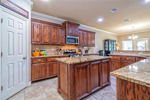4522 Big Cyprus, Corpus Christi, TX 78410 - kitchen featuring decorative backsplash, a kitchen island, appliances with stainless steel finishes, a notable chandelier, and hanging light fixtures