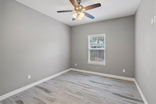 spare room with ceiling fan, light wood-style flooring, and baseboards