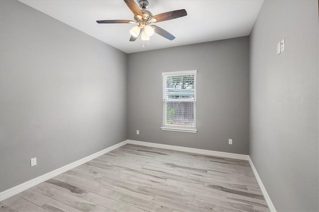spare room with ceiling fan, light wood-style flooring, and baseboards