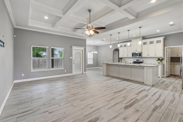 kitchen featuring stainless steel microwave, open floor plan, gas range, light wood finished floors, and baseboards