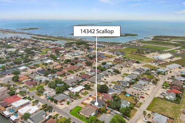 aerial view of property's location featuring a large body of water and nearby suburban area