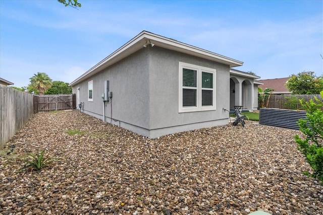 back of house featuring a fenced backyard and stucco siding