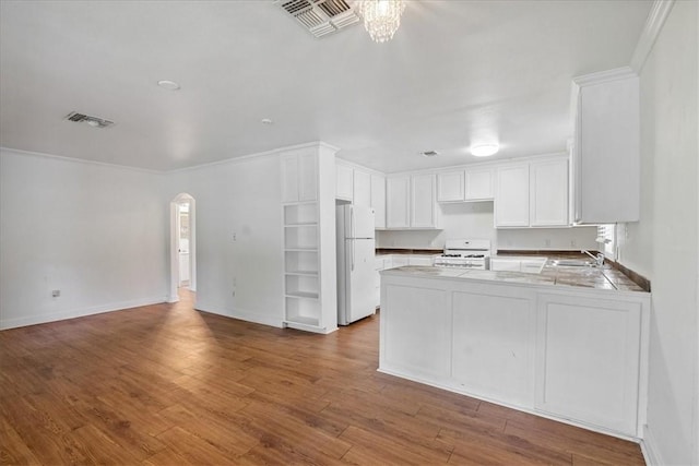 330 Ohio Ave, Corpus Christi, TX 78404 - kitchen with white appliances, open floor plan, a peninsula, arched walkways, and white cabinetry