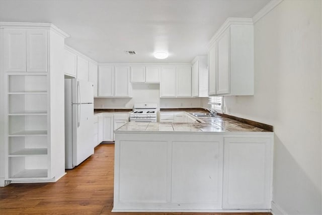 330 Ohio Ave, Corpus Christi, TX 78404 - kitchen featuring white appliances, a peninsula, and white cabinetry