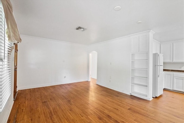 330 Ohio Ave, Corpus Christi, TX 78404 - unfurnished living room with arched walkways, light wood-style floors, and ornamental molding