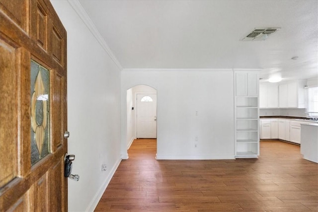 330 Ohio Ave, Corpus Christi, TX 78404 - unfurnished living room featuring ornamental molding, arched walkways, and wood finished floors