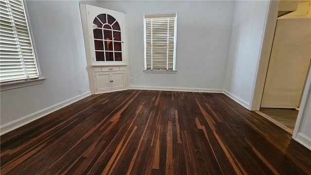 unfurnished dining area with dark wood-type flooring