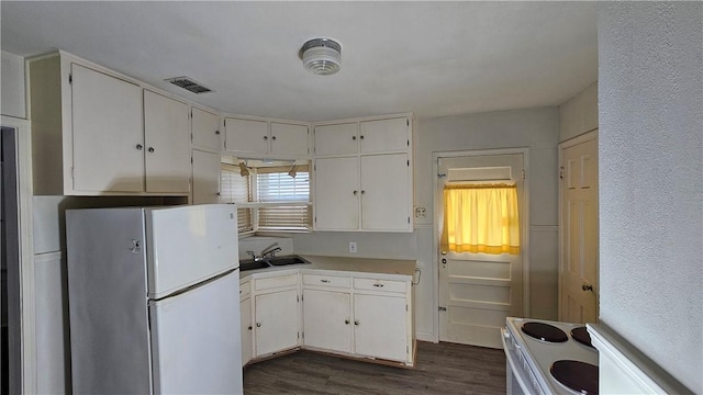 kitchen featuring sink, white cabinetry, white appliances, and dark hardwood / wood-style floors