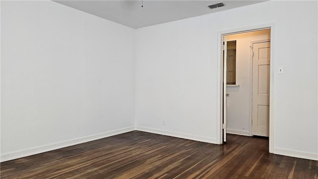 unfurnished room with dark wood-type flooring