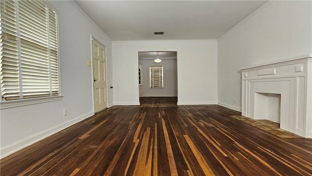 unfurnished living room featuring dark hardwood / wood-style flooring and ornamental molding