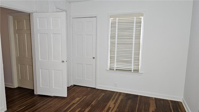 unfurnished bedroom with a closet and dark hardwood / wood-style floors