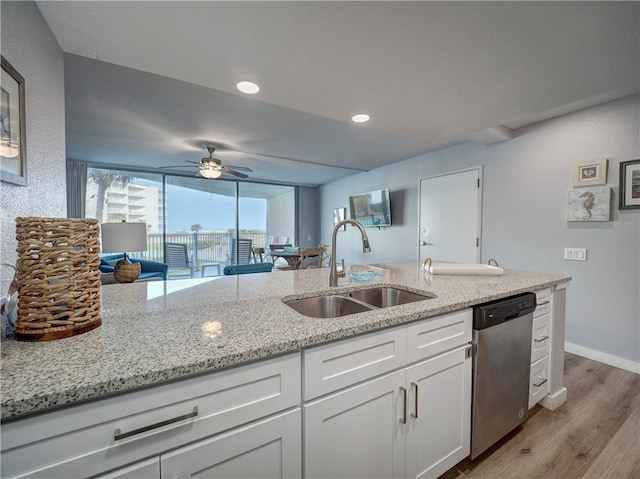 kitchen featuring light stone counters, sink, light hardwood / wood-style floors, white cabinets, and dishwasher