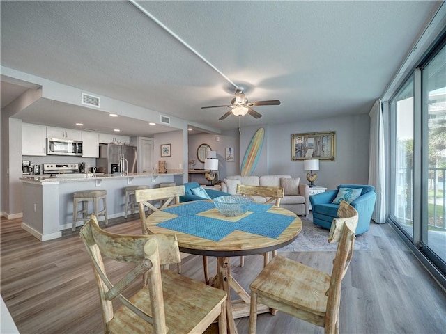 800 Sandcastle Dr Unit 129, Port Aransas, TX 78373 - dining area featuring light wood-style flooring, ceiling fan, a textured ceiling, and baseboards