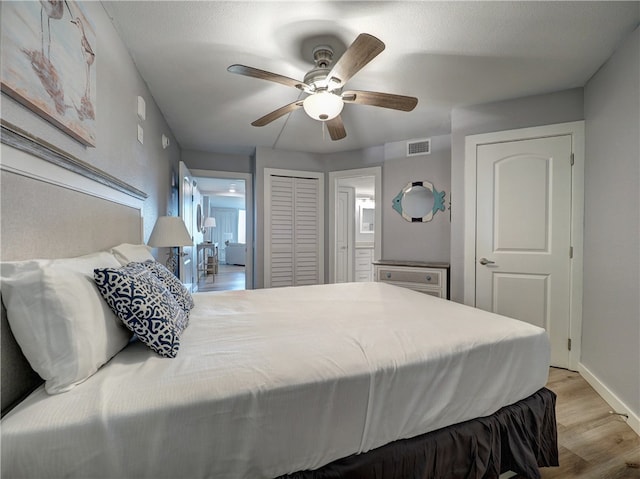 bedroom with light hardwood / wood-style floors, ceiling fan, and ensuite bathroom