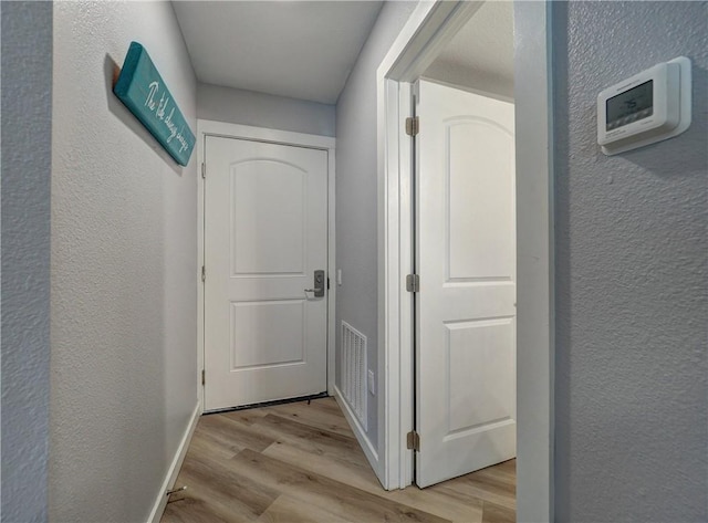 800 Sandcastle Dr Unit 129, Port Aransas, TX 78373 - corridor featuring light wood-style floors, a textured wall, and baseboards