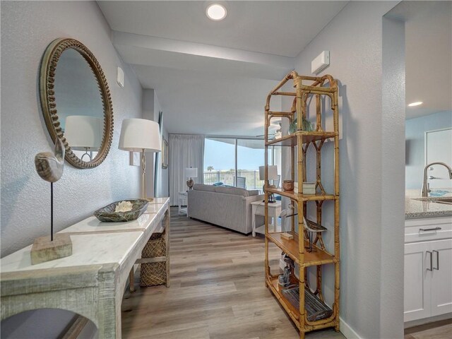 800 Sandcastle Dr Unit 129, Port Aransas, TX 78373 - corridor with light wood-style flooring, a sink, and a textured wall