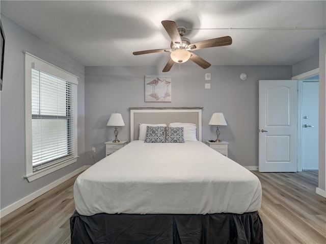 bedroom with light hardwood / wood-style floors and ceiling fan