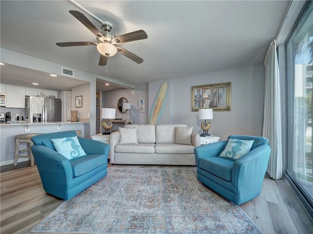 800 Sandcastle Dr Unit 129, Port Aransas, TX 78373 - living room featuring light wood-style floors, ceiling fan, and a textured ceiling