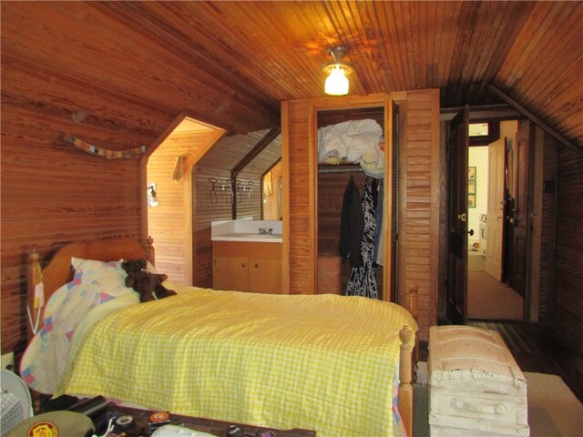 bedroom with lofted ceiling, wood ceiling, hardwood / wood-style floors, wood walls, and a closet