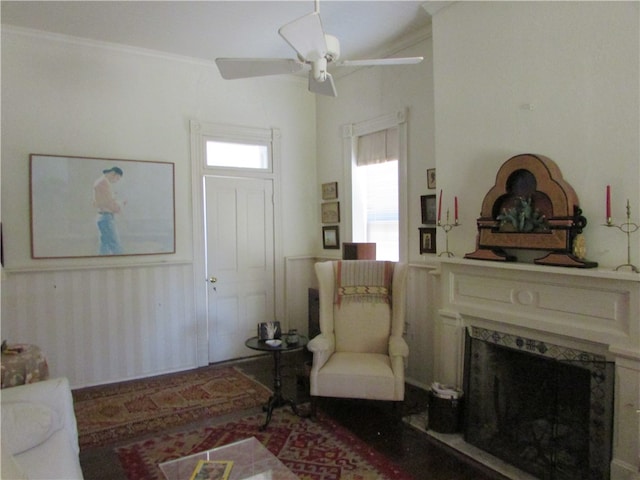 living room featuring ornamental molding, ceiling fan, and a high end fireplace