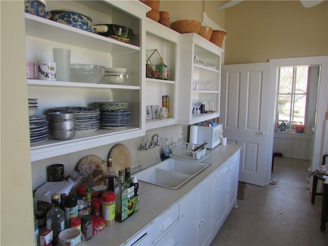 kitchen featuring white cabinets, concrete floors, and sink