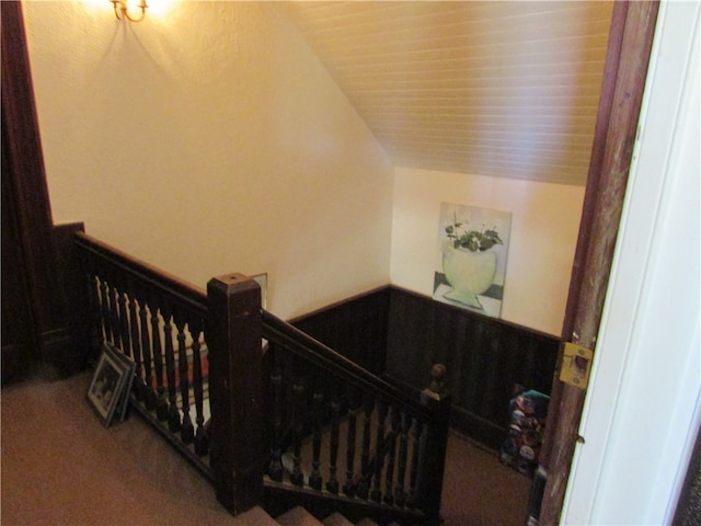 stairway with carpet and vaulted ceiling