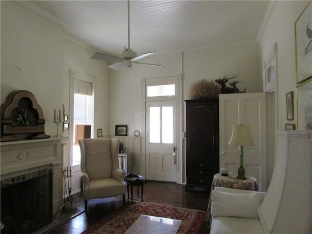 living room with ornamental molding, dark hardwood / wood-style flooring, and ceiling fan