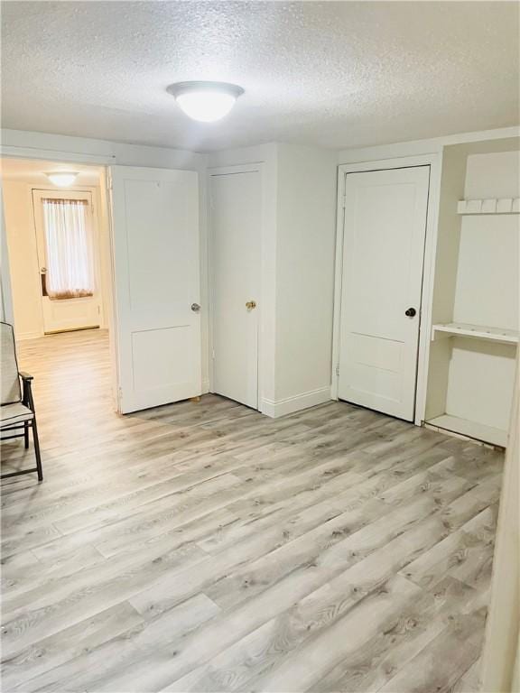 spare room featuring a textured ceiling and light wood-type flooring