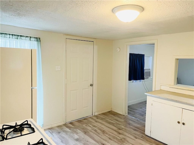 interior space with cooling unit, light hardwood / wood-style floors, and a textured ceiling