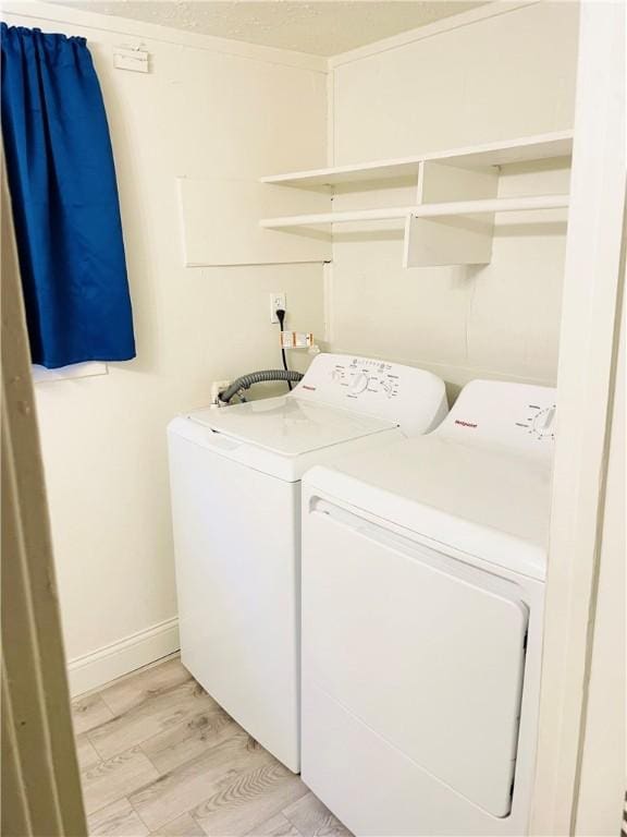 washroom featuring washer and clothes dryer and light hardwood / wood-style floors