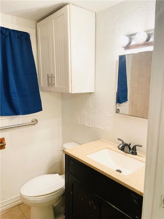 bathroom with tile patterned flooring, vanity, and toilet