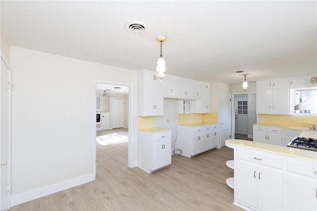 kitchen featuring decorative light fixtures, white cabinetry, light hardwood / wood-style flooring, and ceiling fan