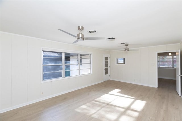 empty room with ceiling fan, crown molding, and light hardwood / wood-style flooring