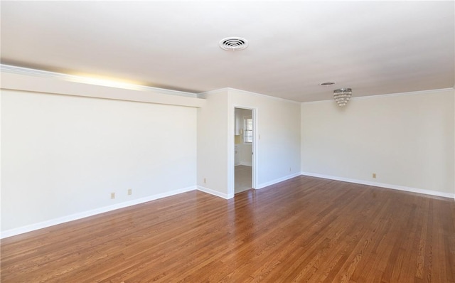 unfurnished room with ornamental molding and hardwood / wood-style floors