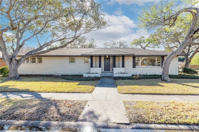 single story home featuring covered porch and a front lawn