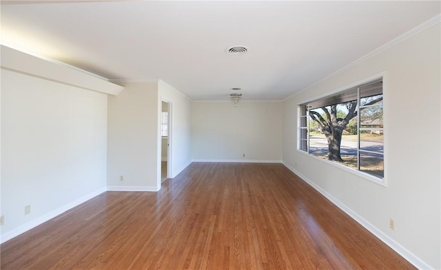 spare room with crown molding and hardwood / wood-style floors