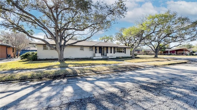 ranch-style home featuring a front lawn