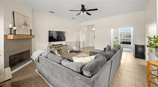 tiled living room with ceiling fan and crown molding