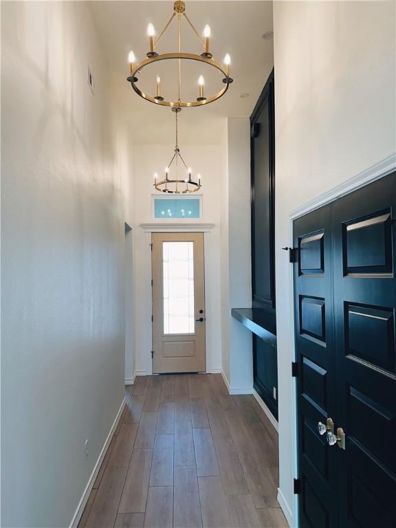 entryway featuring visible vents, baseboards, a notable chandelier, and wood finished floors