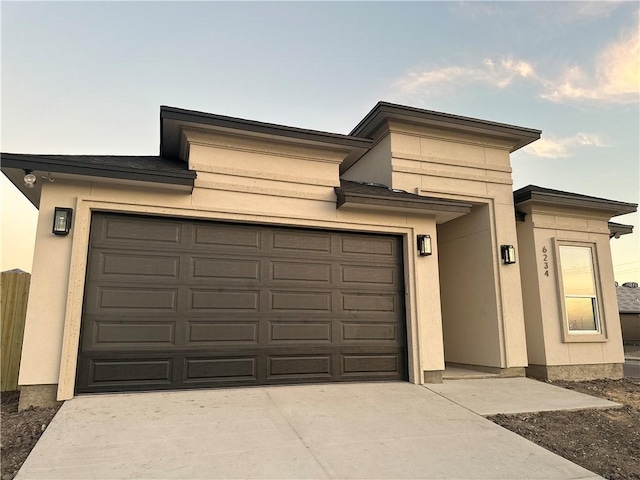 prairie-style house featuring an attached garage and stucco siding